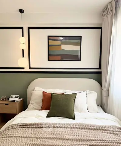 Stylish bedroom with modern decor and cozy bedding, featuring elegant lighting and framed artwork.