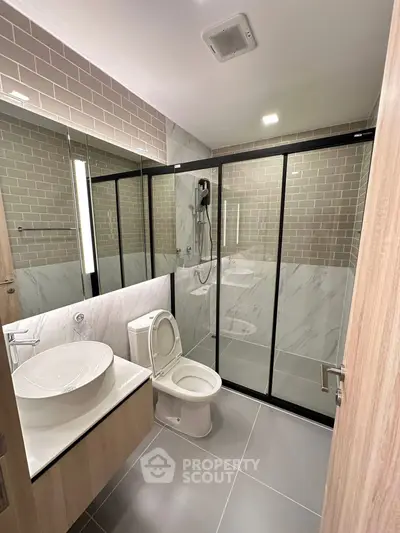 Modern bathroom with sleek design, featuring a glass shower enclosure and stylish vanity.