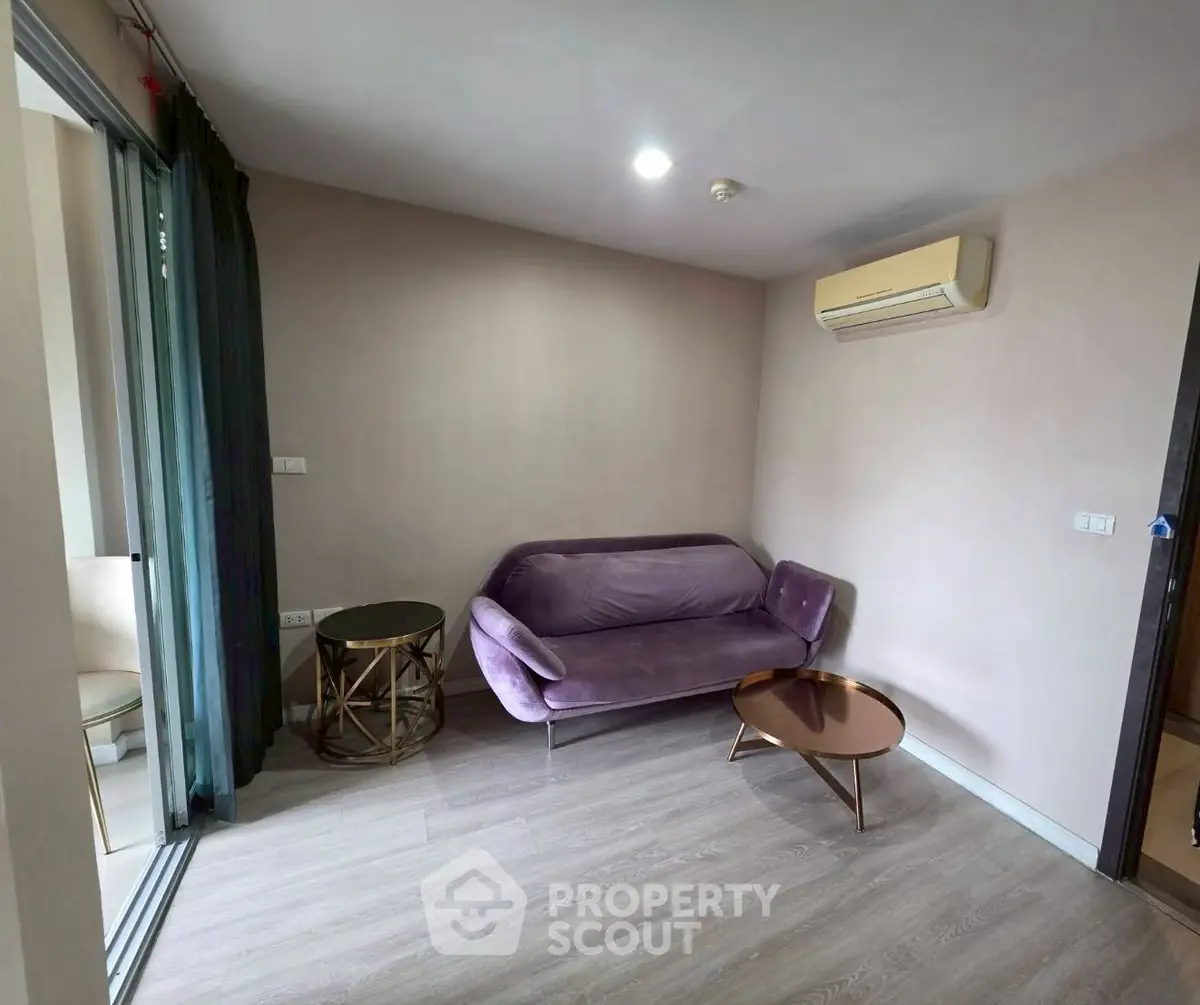 Modern living room with stylish purple sofa and air conditioning in a cozy apartment.