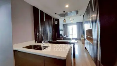 Modern open-layout kitchen and living room with sleek design and ample natural light.