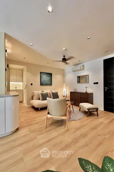 Modern living room with stylish furniture and wooden flooring, featuring a cozy seating area and elegant decor.