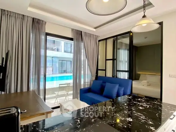 Modern living room with pool view, featuring sleek furniture and stylish decor in a contemporary apartment.