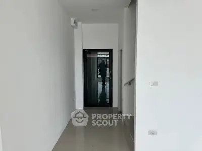 Modern hallway with sleek design and glossy floor tiles in a contemporary building.