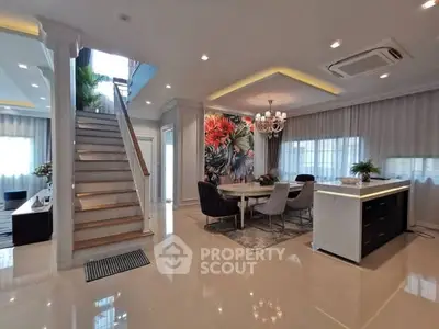 Luxurious open-plan living room with elegant staircase and modern decor