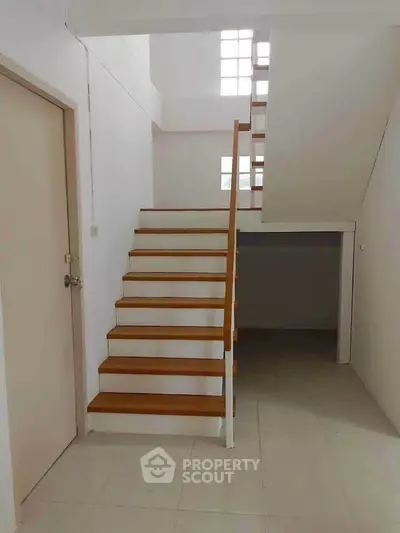 Modern minimalist staircase in a bright interior space with natural light.