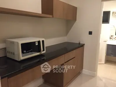 Modern kitchen with sleek cabinetry and microwave, ideal for contemporary living.