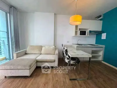 Modern living room with cozy sofa and stylish kitchen in open layout apartment.