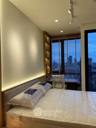 Modern bedroom with city view, featuring stylish lighting and cozy decor, perfect for urban living.
