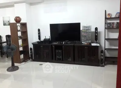 Spacious living room with modern entertainment setup and sleek furniture.