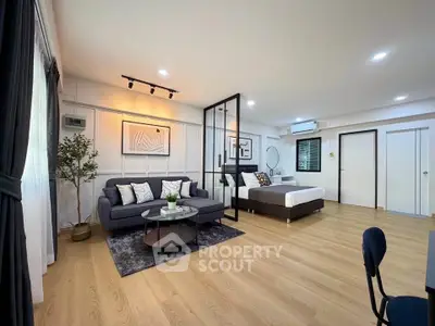 Spacious modern studio apartment with stylish decor and open layout, featuring a cozy living area and comfortable bed.