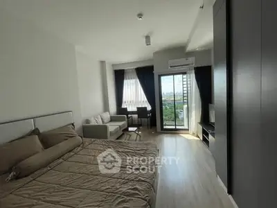 Modern studio apartment with cozy living area and balcony view