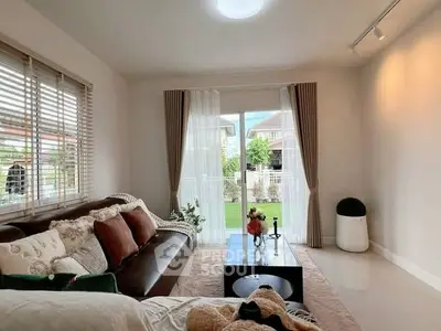 Charming living room with cozy sofa and garden view, perfect for relaxation.