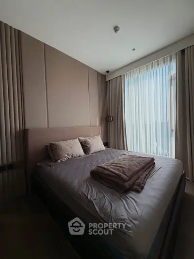 Luxurious bedroom with modern design and large window offering stunning city views.