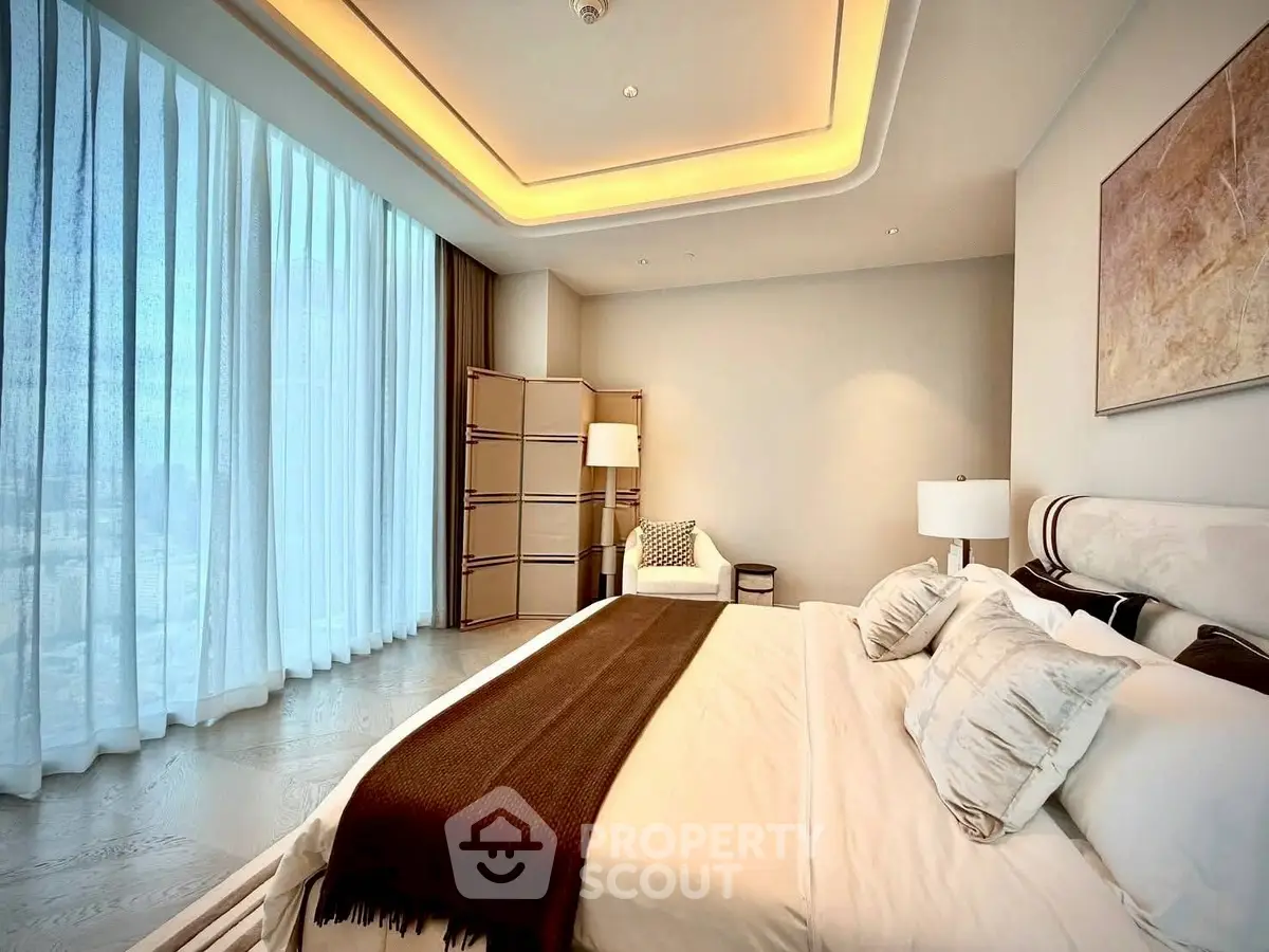 Luxurious bedroom with floor-to-ceiling windows and elegant decor in modern apartment.