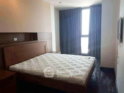 Spacious bedroom with large window and modern furnishings