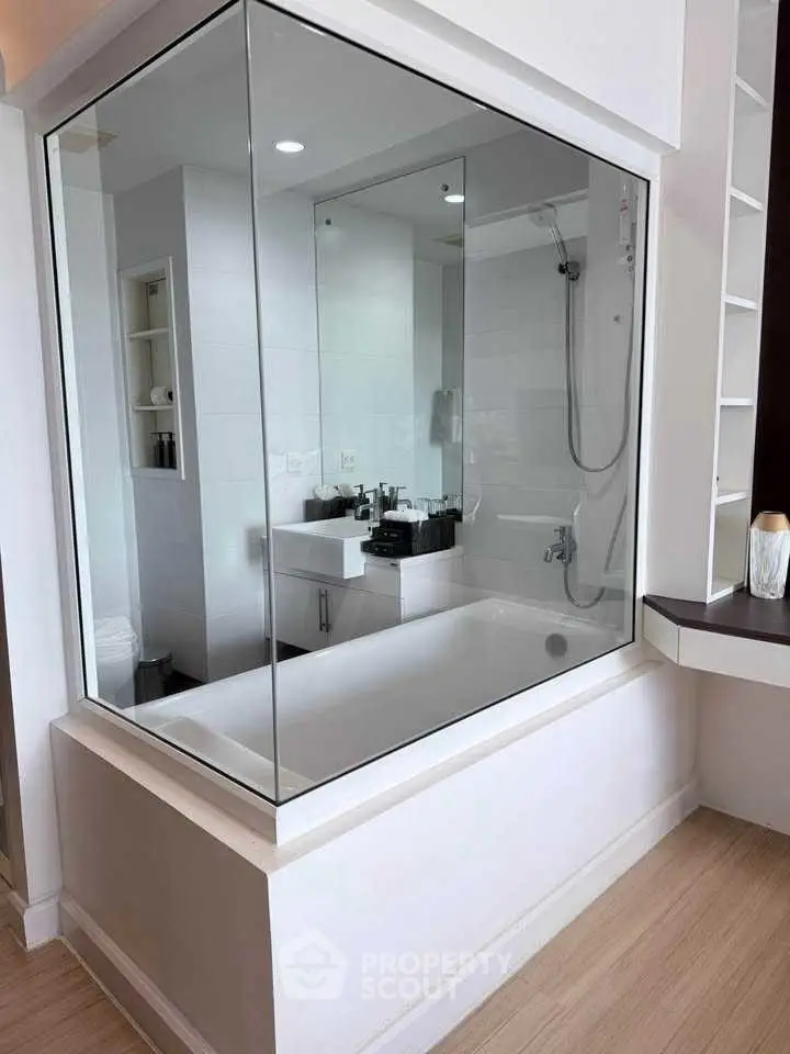 Modern bathroom with glass-enclosed bathtub and sleek fixtures