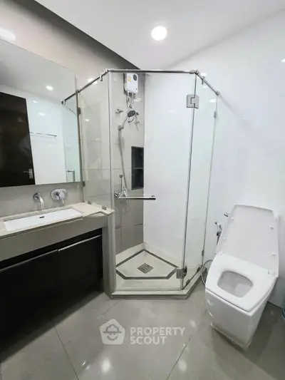 Modern bathroom with glass shower enclosure and sleek fixtures