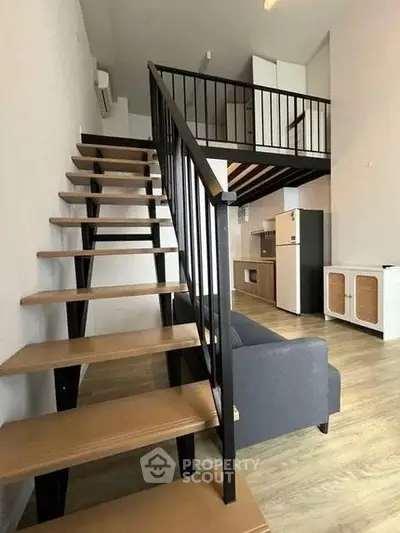 Modern loft apartment with stylish staircase and open kitchen layout, perfect for urban living.
