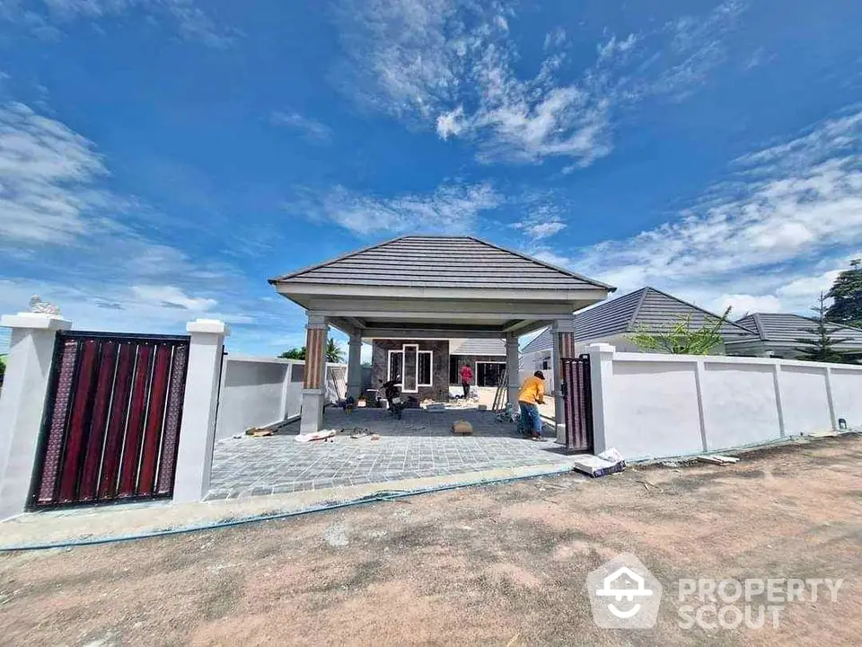 Charming single-story house with spacious front yard and modern design under clear blue sky.