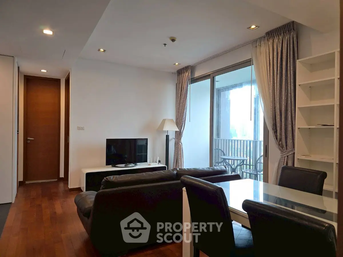 Modern living room with sleek furniture and large windows opening to a balcony, perfect for urban living.
