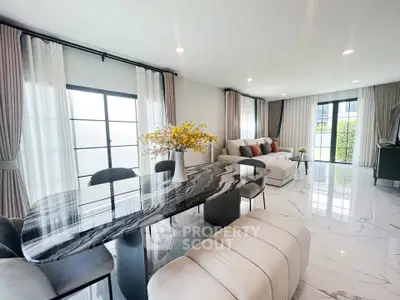 Spacious modern living room with elegant marble dining table and cozy seating area, flooded with natural light.