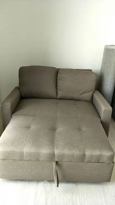 Cozy brown sofa bed in a modern living room setting, perfect for small spaces.