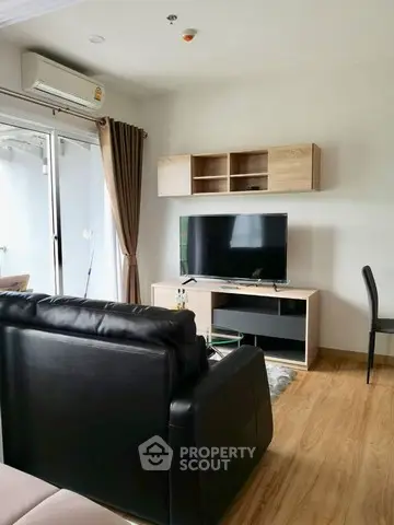 Modern living room with sleek furniture and wall-mounted TV, featuring a cozy ambiance.