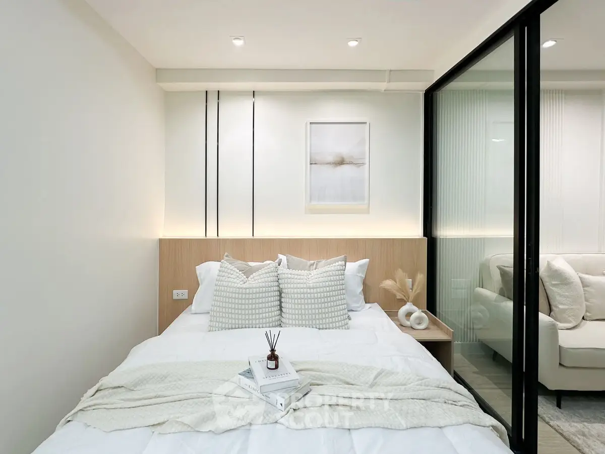 Modern bedroom with elegant decor and glass partition to living area