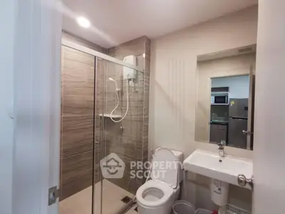Modern bathroom with glass shower and sleek fixtures in a contemporary apartment.