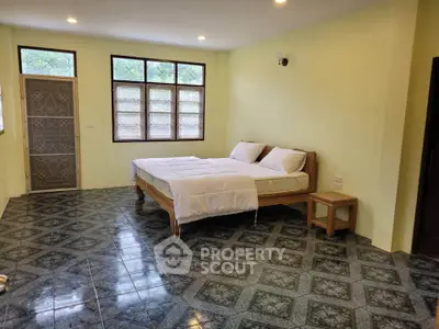 Spacious bedroom with tiled floor and large windows for natural light