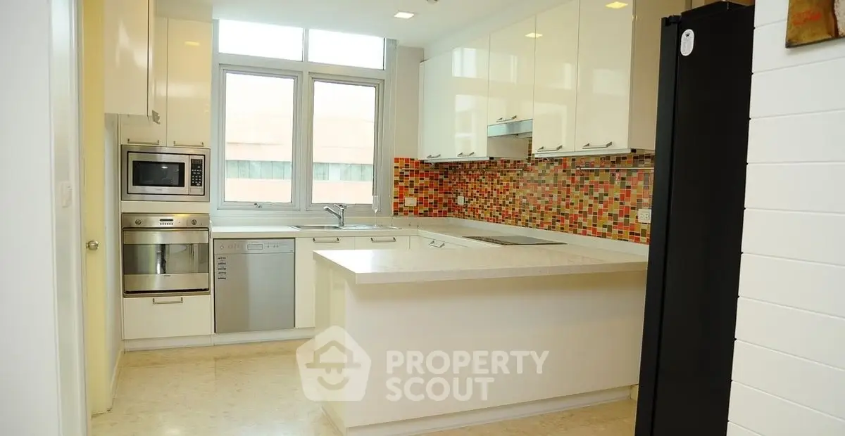 Modern kitchen with colorful backsplash and stainless steel appliances