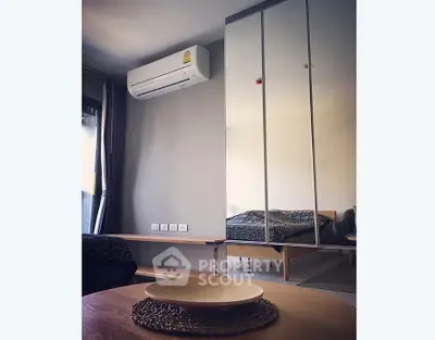 Modern bedroom with mirrored wardrobe and air conditioning unit