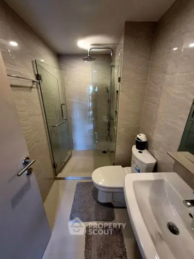 Modern bathroom with glass shower and sleek fixtures in a contemporary apartment.