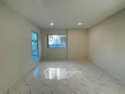 Spacious empty room with large windows and elegant marble flooring