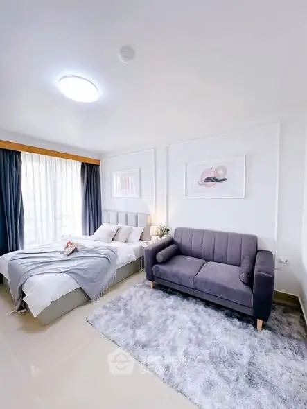 Modern bedroom with cozy bed and stylish sofa in bright, airy space.