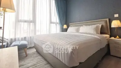 Luxurious bedroom with elegant decor and large windows for natural light.