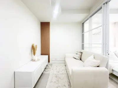 Bright and modern living room with sleek white furniture and elegant decor