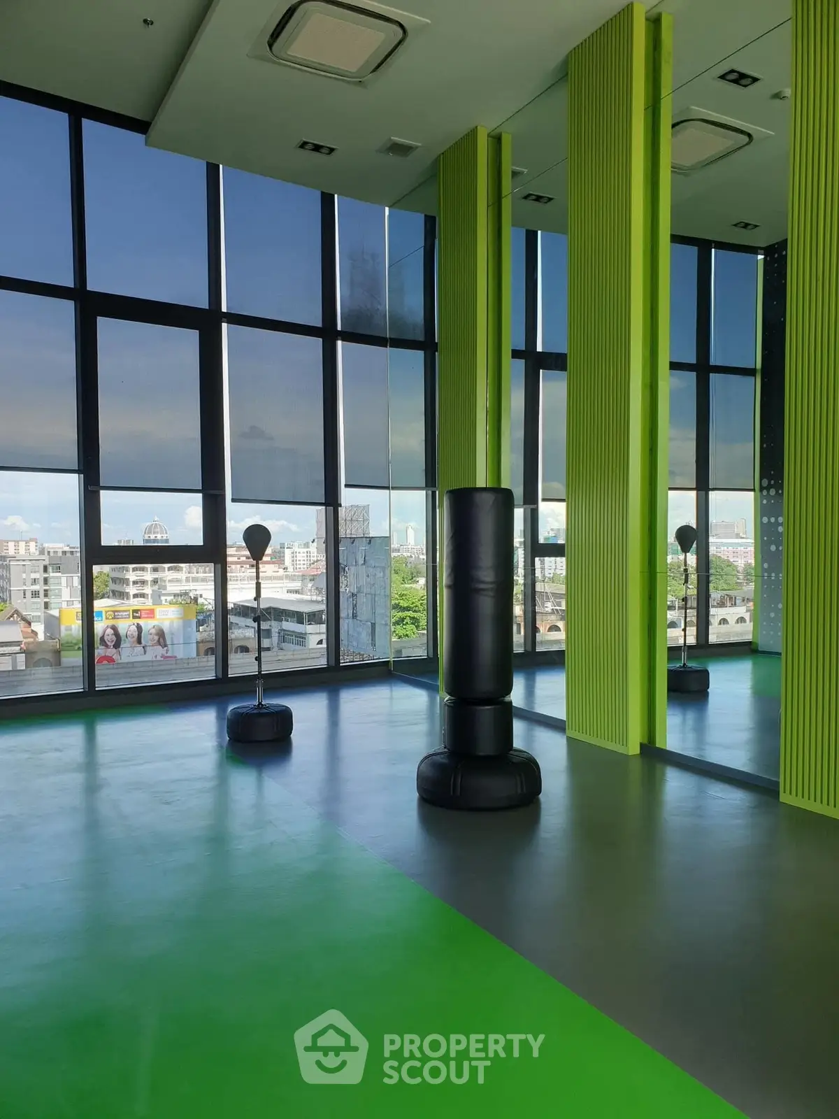 Modern gym with panoramic city views and vibrant green accents