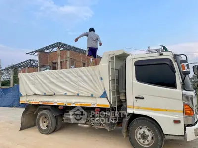 Construction site with truck and worker, showcasing building progress and development potential.