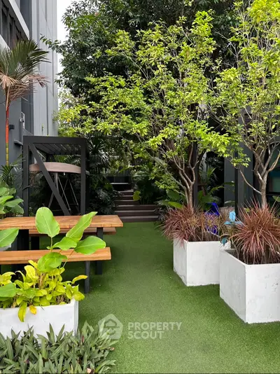 Charming garden area with lush greenery and modern outdoor seating, perfect for relaxation and gatherings.