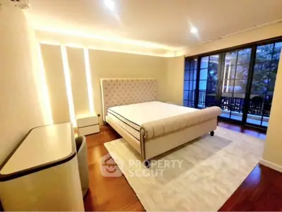Luxurious bedroom with elegant bed and large windows opening to a scenic balcony view.