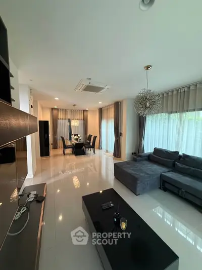 Spacious modern living room with elegant dining area and large windows for natural light.