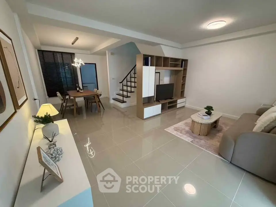Spacious modern living room with elegant decor and open dining area, perfect for family gatherings.