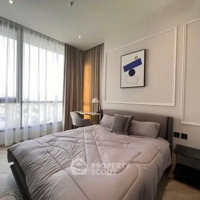 Modern bedroom with stylish decor and large window offering natural light