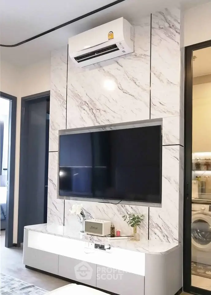 Modern living room with marble accent wall, sleek TV setup, and air conditioning unit.