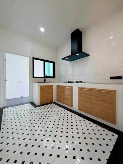 Modern kitchen with sleek cabinetry and stylish tile flooring, featuring a gas stove and ample natural light.