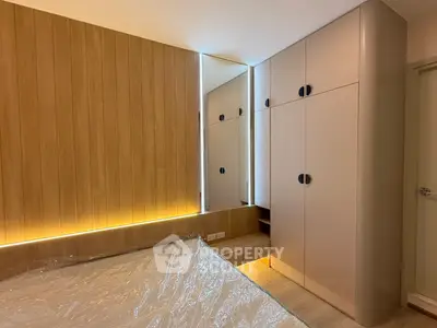Modern bedroom with sleek built-in wardrobe and ambient lighting