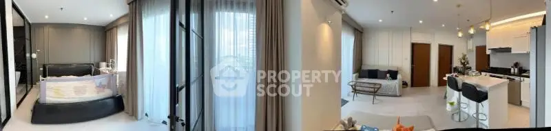 Spacious modern apartment with open living room and kitchen, featuring large windows and elegant decor.