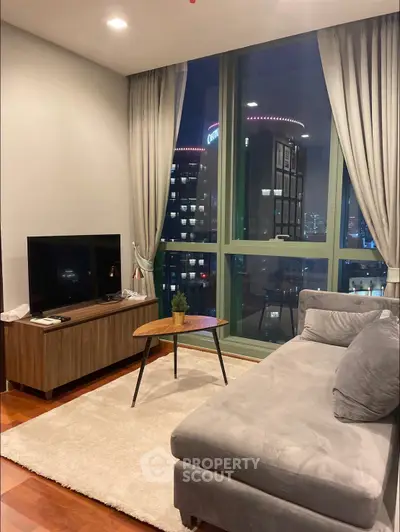 Modern living room with city view, cozy sofa, and stylish decor in high-rise apartment.
