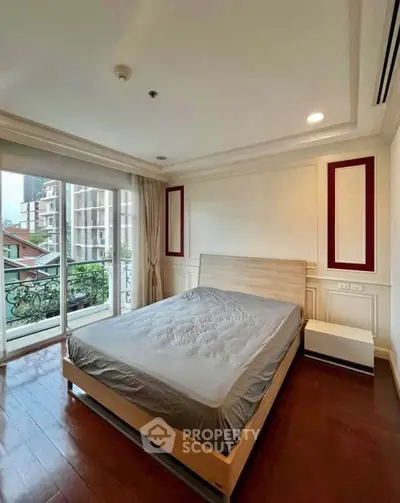 Spacious bedroom with balcony and city view in modern apartment